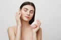 Beauty and skincare concept. Studio portrait of gentle good-looking european woman rubbing in facial cream, enjoying