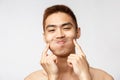 Beauty, skincare and men health concept. Headshot of funny, handsome silly asian man with naked torso, fool around over