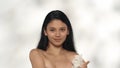 Closeup studio shot of attractive young model. Beautiful asian girl with long hair touching her chest skin with white Royalty Free Stock Photo