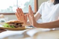 Beauty slim female body confuse hamburger. Woman in restaurant achieves weight loss goal for healthy life, crazy about thinness, Royalty Free Stock Photo