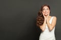 Beauty smiling brunette woman with long shiny wavy black hair looking up aside and standing on black banner background Royalty Free Stock Photo