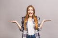 Beauty smiling young woman pointing away and looking isolated over grey background. Free copyspace for product or text Royalty Free Stock Photo