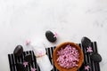 Beauty, spa background with massage stone and flowers in bowl on white table from above. Relaxation and wellness concept. Flat lay