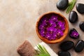 Beauty, spa background with massage stone and flowers on brown background top view. Relaxation and wellness concept. Flat lay