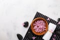 Beauty, spa background with massage stone, towel and flowers in bowl on white table top view. Relaxation and wellness concept.