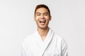 Beauty, spa and leisure concept. Cheerful asian man spending weekends to relax at hot springs, wear bathrobe laughing