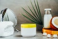 Beauty spa skincare cosmetic mockup cream package with coconut oil, fresh coconut, towel and mirror on dark gray Royalty Free Stock Photo