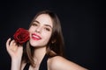 Beauty studio portrait. Beautiful model with red rose flower,  on black studio background. Charming young girl Royalty Free Stock Photo