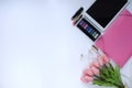 Beauty stuff. Makeup background. Aspects of makeup. Folder, tablet, tulips flowers, headphones, lipsticks and eye shadows on the t