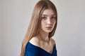 Beauty theme: portrait of a beautiful young girl with freckles on her face and wearing a blue dress on a white background in Royalty Free Stock Photo