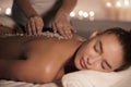 Beauty therapist pouring salt scrub on womans back Royalty Free Stock Photo