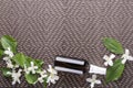 Beauty therapy by using jasmine oil.Spray bottle with jasmine oil on the brown mat, empty space for design