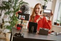 Beauty tips. Young attractive woman showing a makeup palette on camera while recording video review for her beauty blog