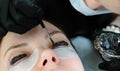 Beauty treatment. Cosmetologist puts black paint on the lashes. laminating eyelashes. Closeup eyes.