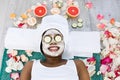 Beauty treatment. Top view of beautiful young African woman lying with pieces of cucumber on her face in spa Royalty Free Stock Photo