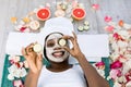 Beauty treatment. Top view of beautiful young African woman lying with pieces of cucumber on her face in spa Royalty Free Stock Photo