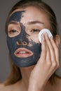 Beauty treatment. Woman taking off mask with cosmetic white pad