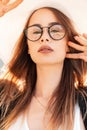 Beauty vogue portrait pretty young gorgeous woman with sexy lips in youth glasses in black jacket in elegant hat on bright sunny Royalty Free Stock Photo
