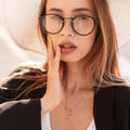 Beauty vogue portrait young gorgeous woman with pretty sexy lips in trendy glasses in vintage black jacket in elegant hat on Royalty Free Stock Photo