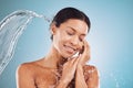 Beauty, water splash and skincare, black woman on blue background in studio. Fashion, health and wellness, clean water