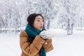 Beauty Winter Asian Girl Blowing Snow in frosty winter Park. Outdoors. Flying Snowflakes Royalty Free Stock Photo