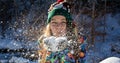 Beauty Winter Girl Blowing Snow in frosty winter Park. Outdoors. Flying Snowflakes. Sunny day. Backlit. Joyful Beauty Royalty Free Stock Photo