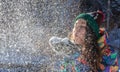 Beauty Winter Girl Blowing Snow in frosty winter Park. Outdoors. Flying Snowflakes. Sunny day. Backlit. Joyful Beauty Royalty Free Stock Photo