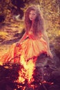 Beauty witch in the woods near the fire. Magic woman celebrating