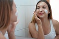 Beauty woman applying cream on her skin. Face moisturizing nourishing invigorating treatments. Enjoying relaxing time at home