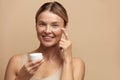 Beauty Woman Applying Face Cream. Female With Fresh Skin Holding Cream Bottle Royalty Free Stock Photo