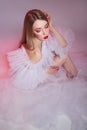 Beauty Woman bright red makeup. Art nude naked woman in a transparent light dress on a pink background. Professional bright makeup