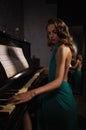 Beauty woman in evening dress playing piano Royalty Free Stock Photo