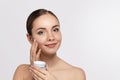 Beauty Woman Face Skin Care. Portrait Of Attractive Young Female Applying Cream And Holding Bottle. Royalty Free Stock Photo