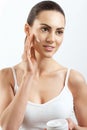 Beauty Woman Face Skin Care.  Woman Face Skin Care. Portrait Of Attractive Young Female Applying Cream  And Holding Bottle. Royalty Free Stock Photo