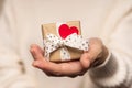 Beauty Woman hands holding Gift box with red heart and heart on light background, close-up. pastel colors, copy space Royalty Free Stock Photo