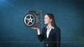 Beauty woman holding car tires on the open hand palm, over isolated studio background. Business and auto concept. Royalty Free Stock Photo