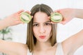 Beauty woman holding slices of Kiwi fruit. Close-up portrait of young naked Caucasian girl is standing and looking at Royalty Free Stock Photo