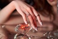 Beauty Woman holds big diamond in hand while lying on table. Beautiful hands, professional manicure, large brilliant