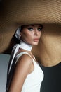 Beauty woman in a large wicker hat and light summer dress. Smokey makeup, perfect portrait of a woman