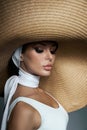 Beauty woman in a large wicker hat and light summer dress. Smokey makeup, perfect portrait of a woman