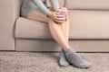 beauty woman legs with socks posing in winter sitting on a couch at home drinks warm tea. Royalty Free Stock Photo