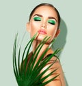 Beauty woman with natural green palm leaf. Portrait of model girl with perfect makeup, green eyeshadows Royalty Free Stock Photo