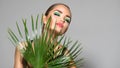 Beauty Woman with natural green palm leaf Portrait, model girl with perfect makeup, green eyeshadows Royalty Free Stock Photo