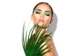 Beauty woman with natural green palm leaf. Portrait of model girl with perfect makeup, green eyeshadows Royalty Free Stock Photo