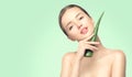 Beauty woman with perfect skin holding fresh leaf of Aloe Vera. Portrait of beautiful brunette spa girl. Skincare Royalty Free Stock Photo