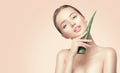 Beauty woman with perfect skin holding fresh leaf of Aloe Vera. Portrait of beautiful brunette spa girl. Skincare Royalty Free Stock Photo