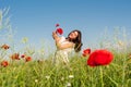 Beauty woman in poppy field in white dress holding a poppies bouquet Royalty Free Stock Photo