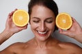 Beautiful smiling caucasian woman with natural makeup, glowing facial skin and citrus fruit. Vitamin C concept. Royalty Free Stock Photo