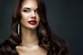 Beauty Woman Red Full Lips Makeup. Fashion Model Face Make up with Curly Black Hair over Dark Background. Elegant Lady Close up Royalty Free Stock Photo