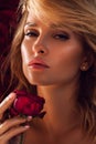 Beauty Woman with red rose. Fashion Brunette Model Girl face Portrait with Red Rose in her hand. Red Lips and Nails. Vogue Style Royalty Free Stock Photo